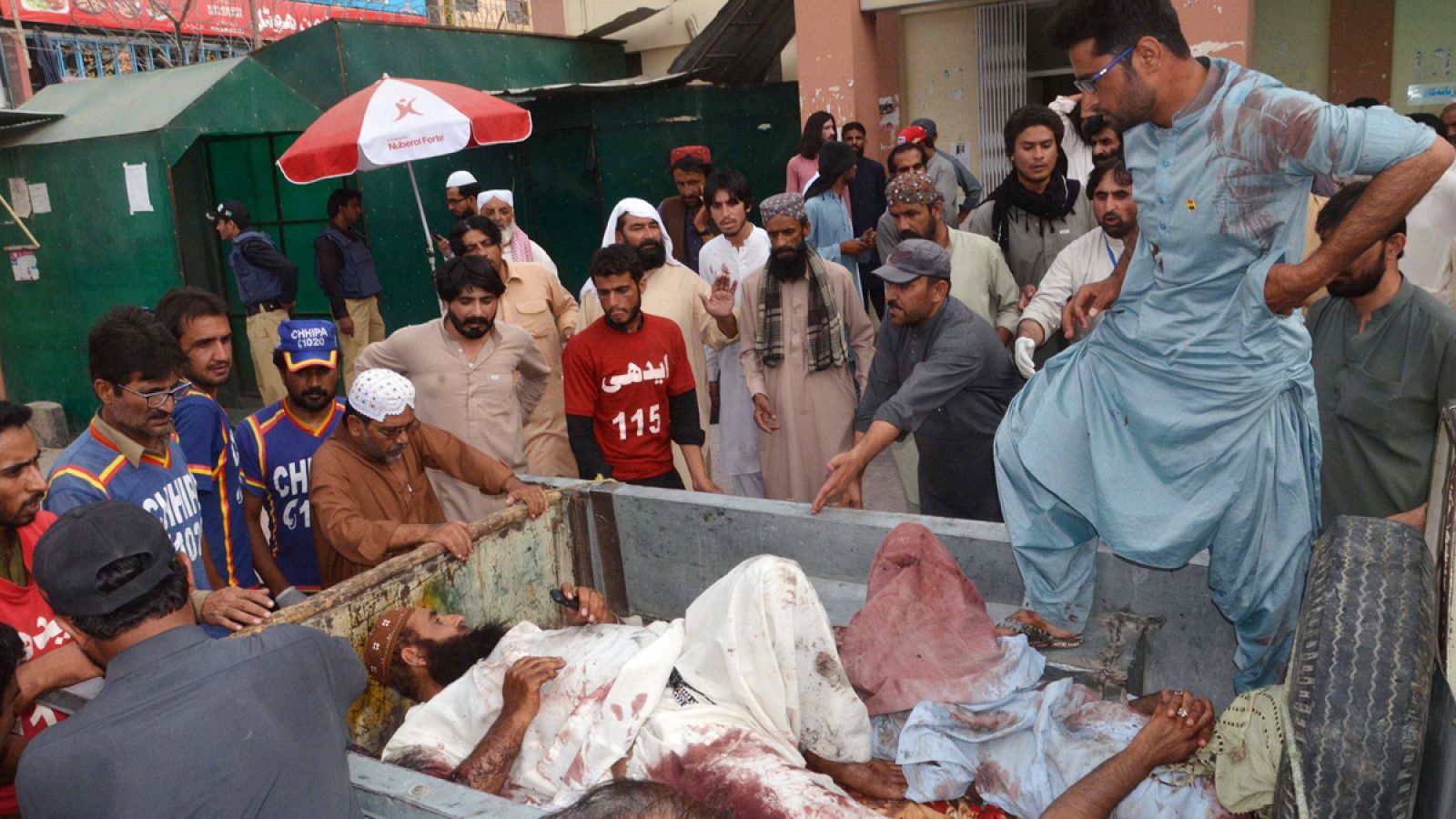 Varios hombres desplazan a víctimas del atentado contra un acto electoral del Partido Nacionalista Awami (ANP) al hospital, en Quetta (Pakistán)