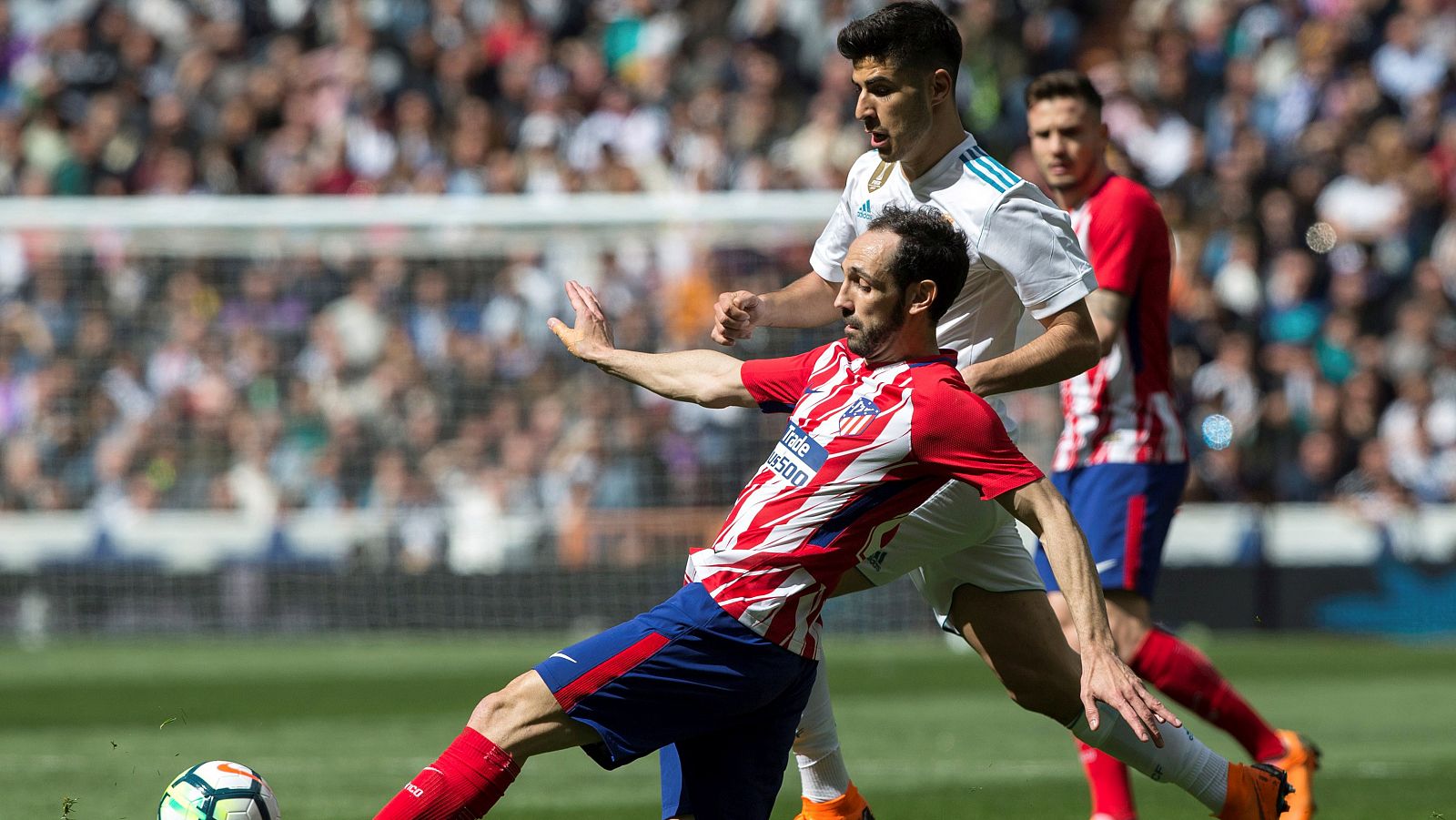 Asensio, del Madrid, pugna con Juanfran, del Atlético, en el derbi de la pasada temporada.