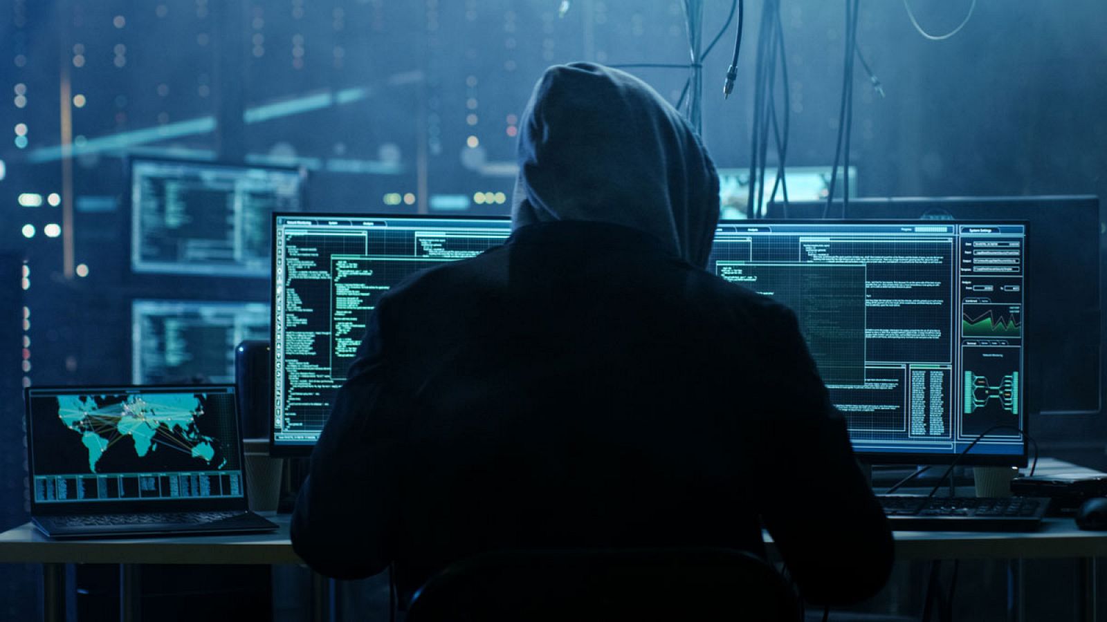 Imagen que representa a un 'hacker' manejando sus ordenadores