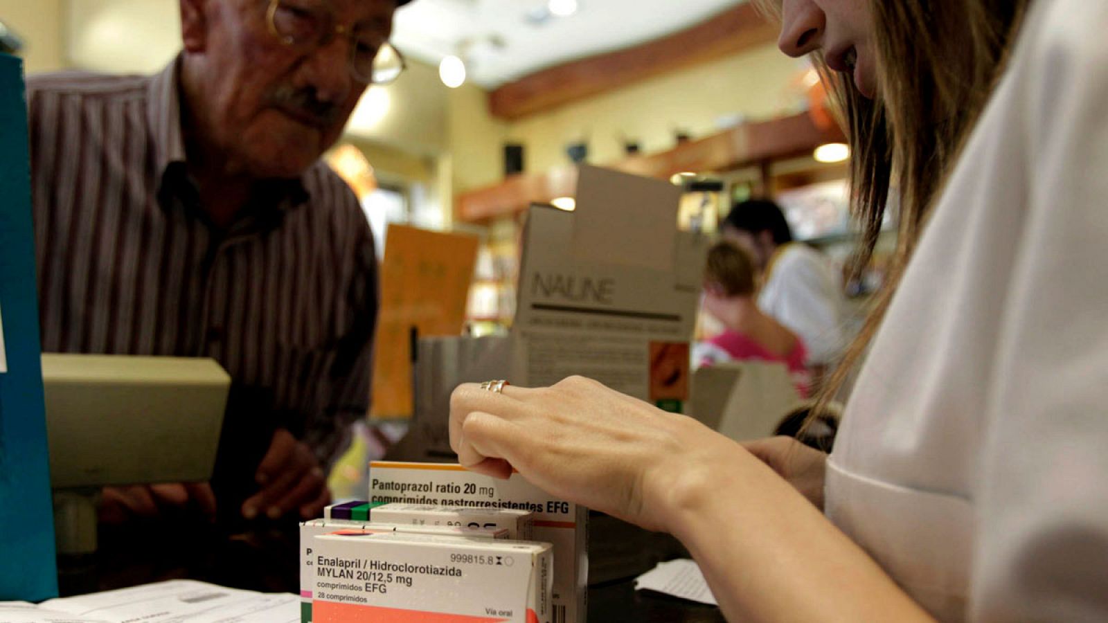 Un hombre adquiere varios medicamentos en una farmacia.