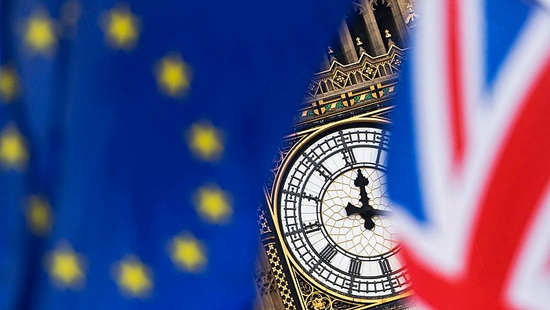 Vista del reloj del Big Ben entre una bandera del Reino Unido y una de la UniVista del reloj del Big Ben entre una bandera del Reino Unido y una de la Unión Europea en una imagen de archivo