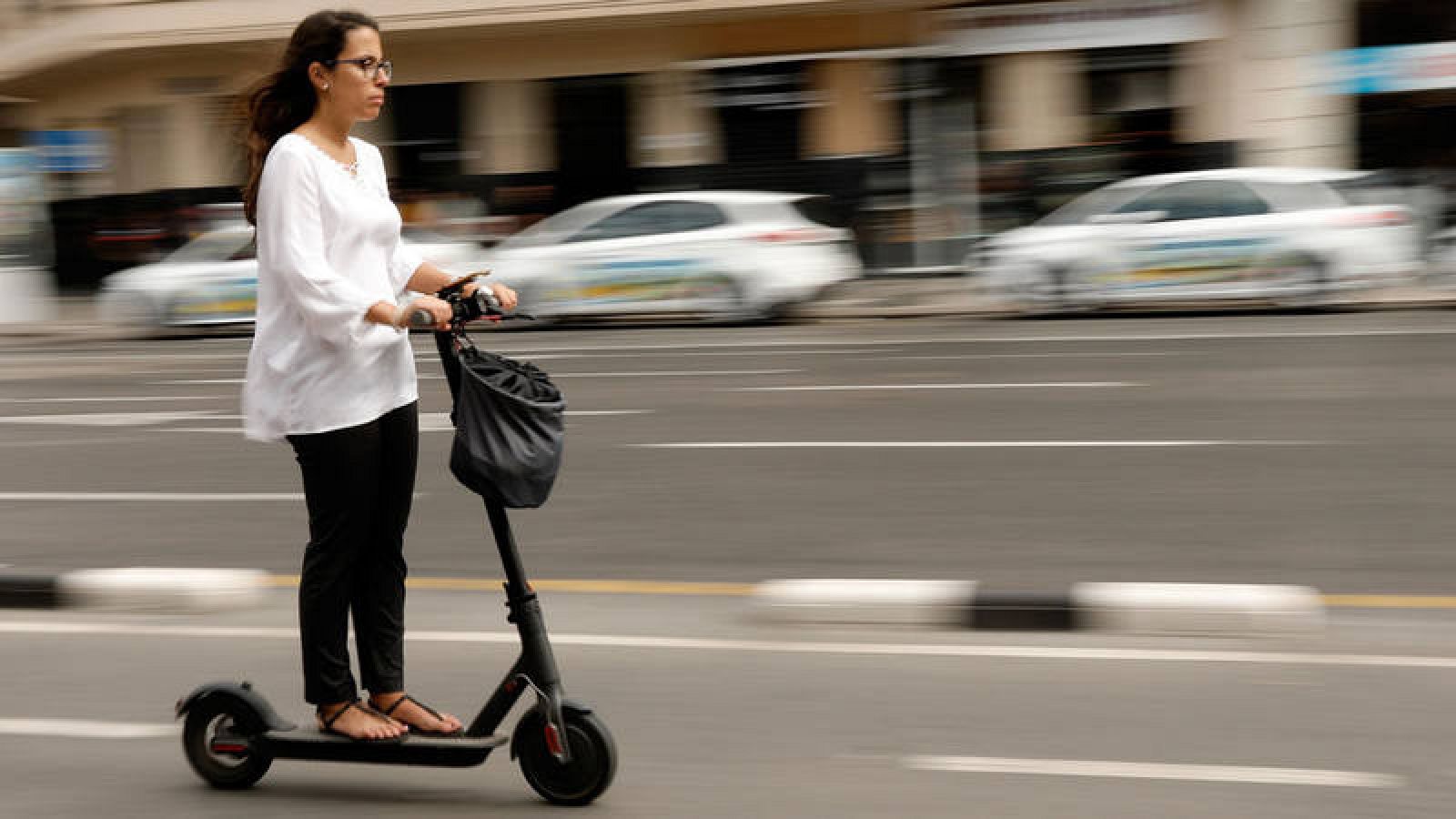 Una mujer circula sobre un patinete eléctrico en Valencia