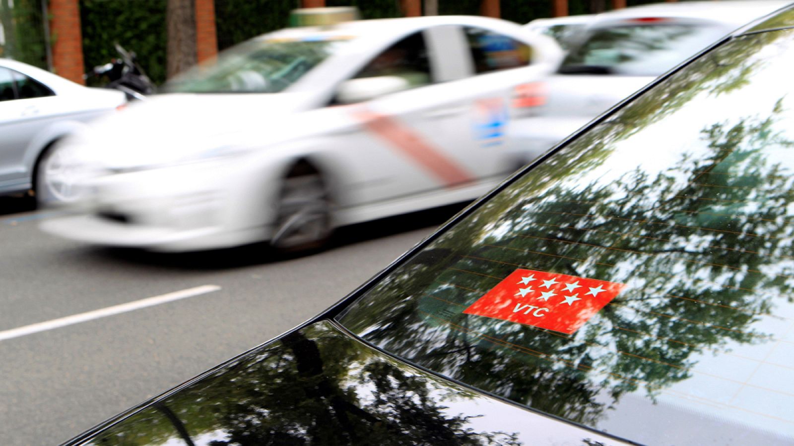 Un VTC en primer plano y detrás un taxi