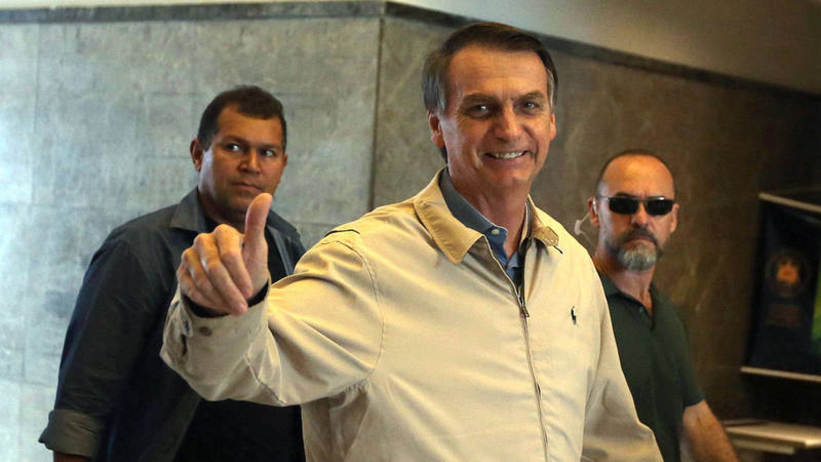 El candidato a la Presidencia de Brasil Jair Bolsonaro (c) hace un gesto hacia la prensa a su salida de la sede de la Policía Federal de Río de Janeiro (Brasil) el miércoles 17 de octubre de 2018. 