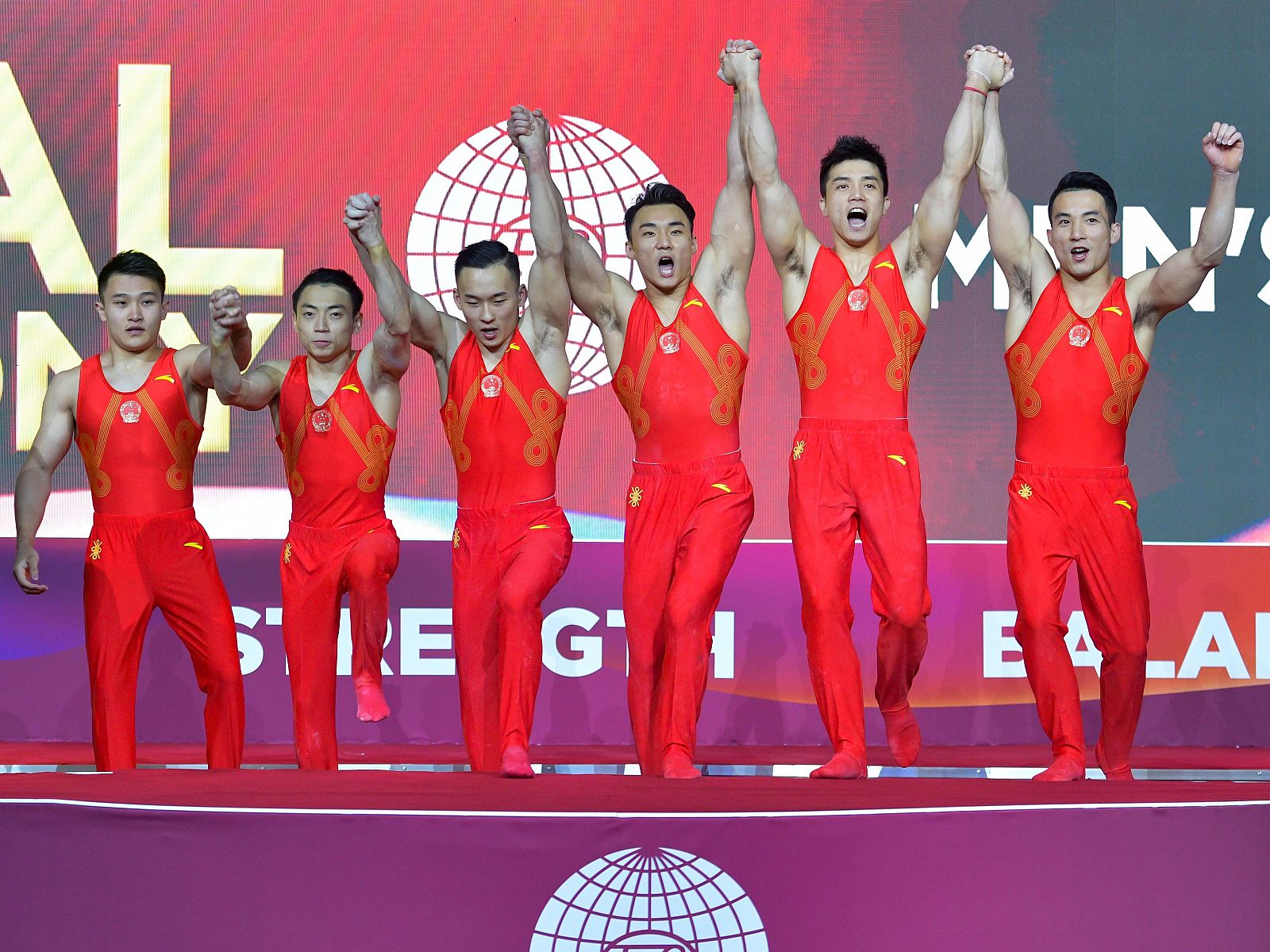 Los atletas chinos celebran en el podio tras ganar la medalla de oro.