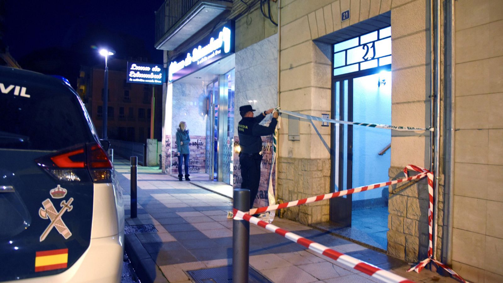 Un agente de la Guardia Civil precinta la entrada del inmueble donde han ocurrido los hechos