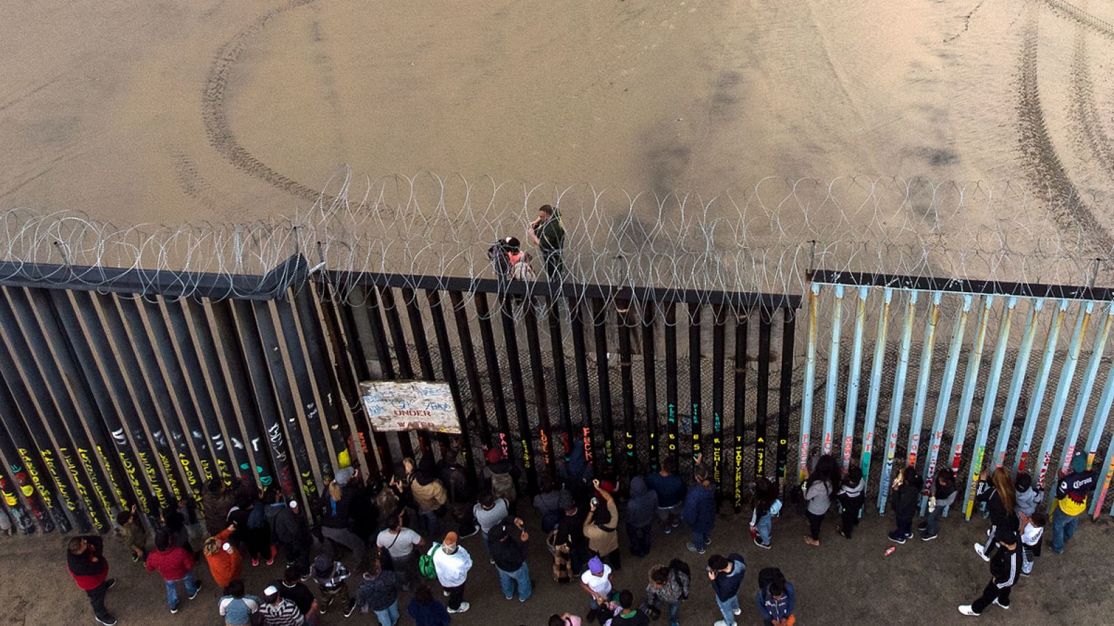 Participantes de la caravana de migrantes centroamericanos se entregan a una patrulla de la Policía tras cruzar la frontera entre México y EE.UU. en Tijuana. Guillermo Arias / AFP