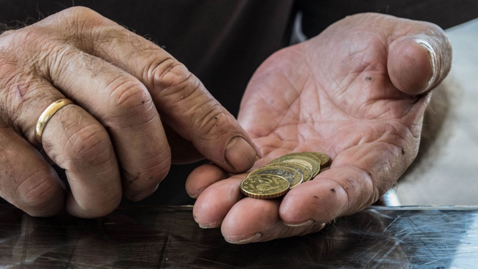 Una persona mayor cuenta monedas