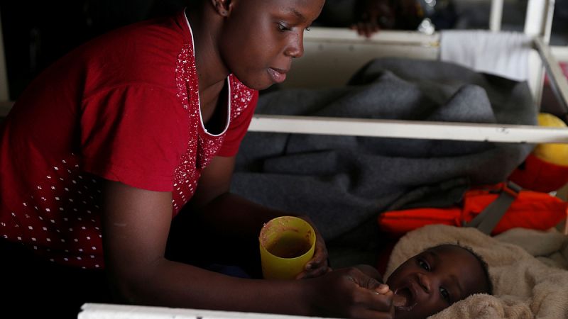 Una mujer da de comer a su hijo a bordo del barco Sea Watch 3