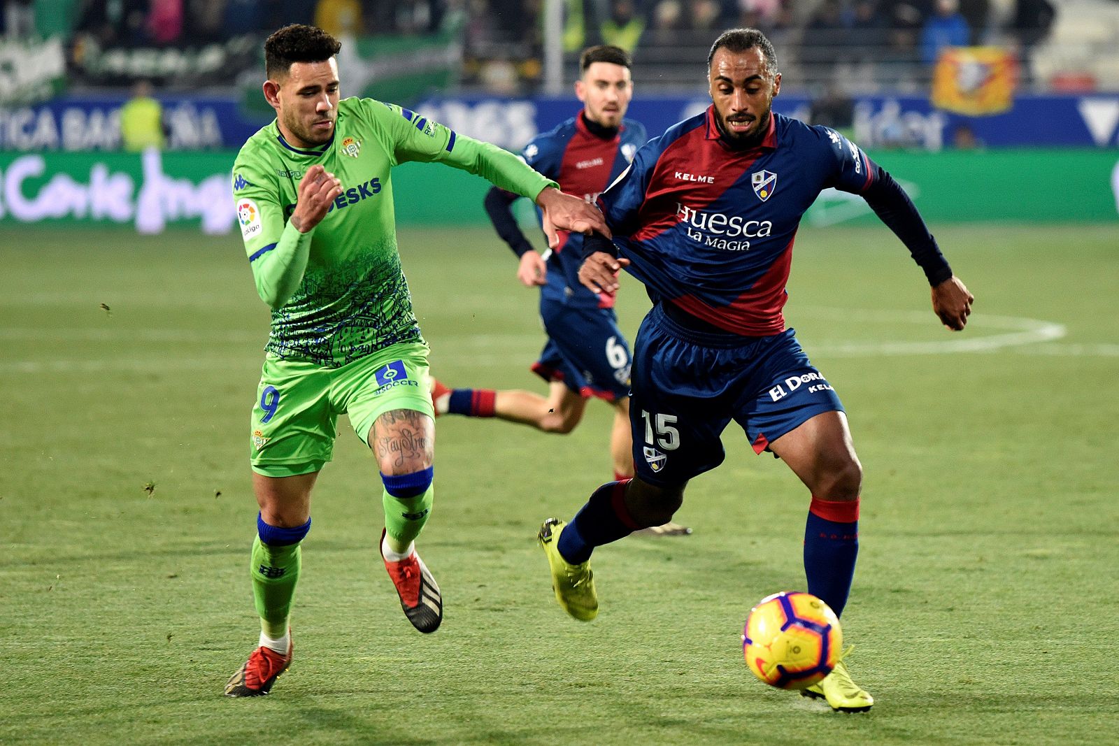 El defensa guineano del Huesca Carlos Akapo (d) lucha el balón con Antonio Sanabria, delantero del Real Betis, durante el partido de la jornada 18ª de Liga en Primera División que se juega esta noche en el El Alcoraz, en Huesca.