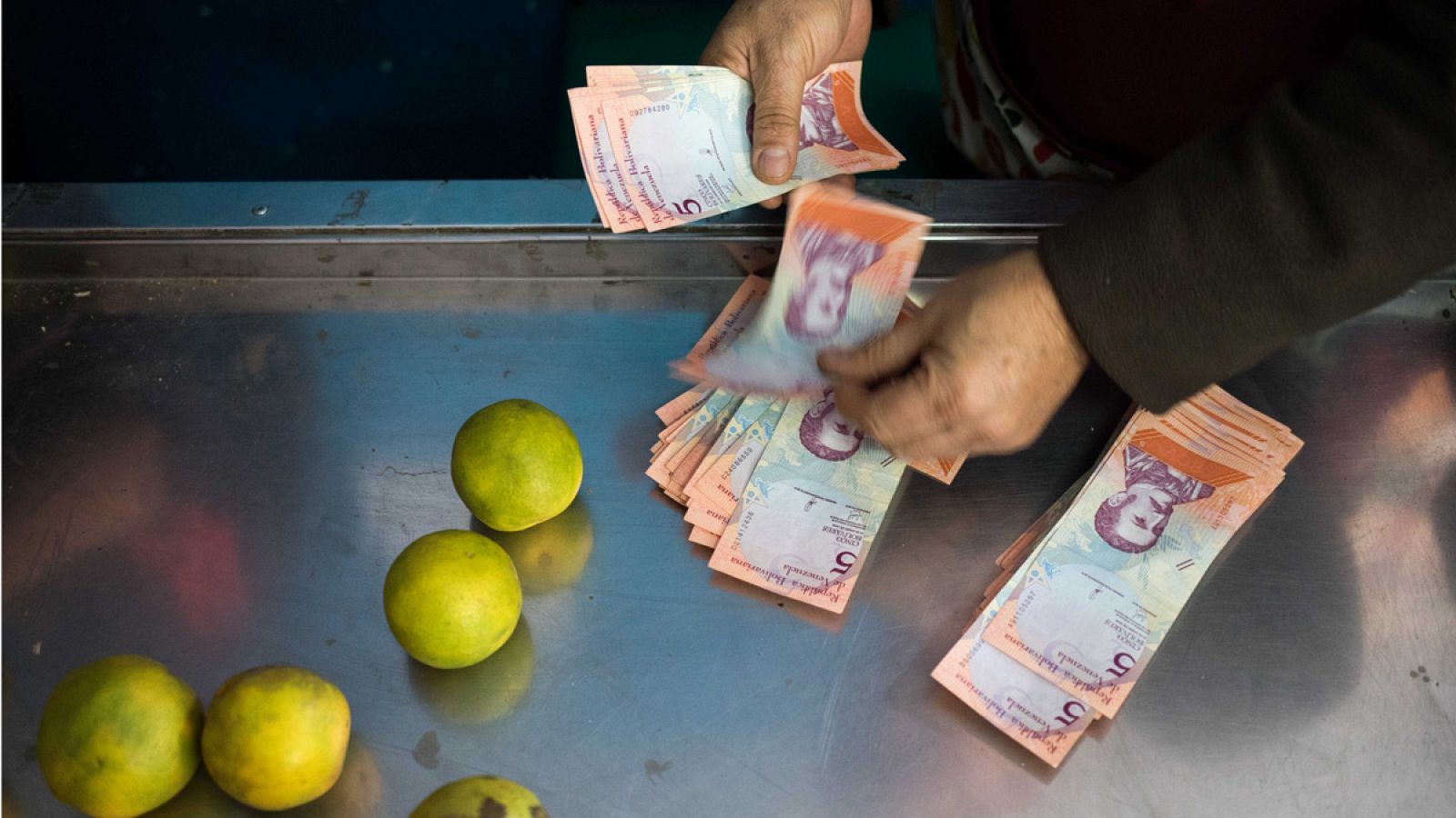 Una mujer paga con bolívares en una tienda de Venezuela