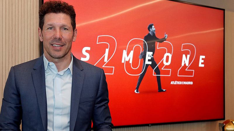 El técnico del Atlético de Madrid, Diego Pablo Simeone, posa junto al cartel de su renovación.