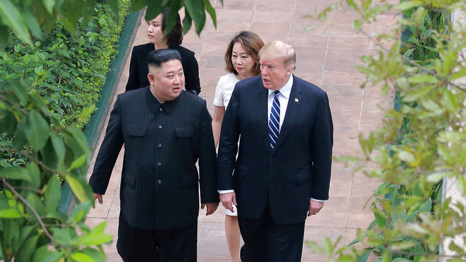 Donald Trump (d) y Kim Jong-un paseando juntos en los jardines de un hotel de Hanoi, Vietnam. 