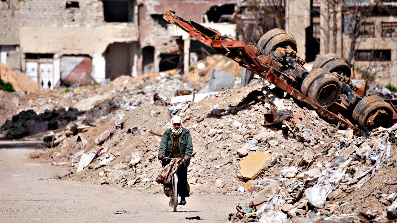 Un hombre atraviesa en bicicleta las ruinas de Guta Oriental, uno de los focos de la resistencia rebelde en Siria hasta el año pasado