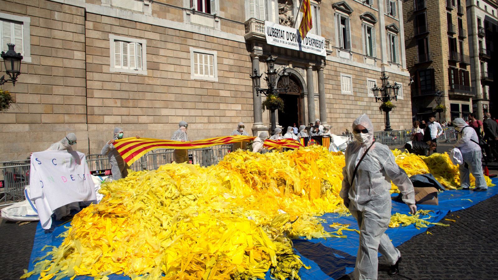 Miembros de la brigada de limpieza de 'Els Segadors del Maresme' depositan miles de lazos amarillos frente al Palau de la Generalitat