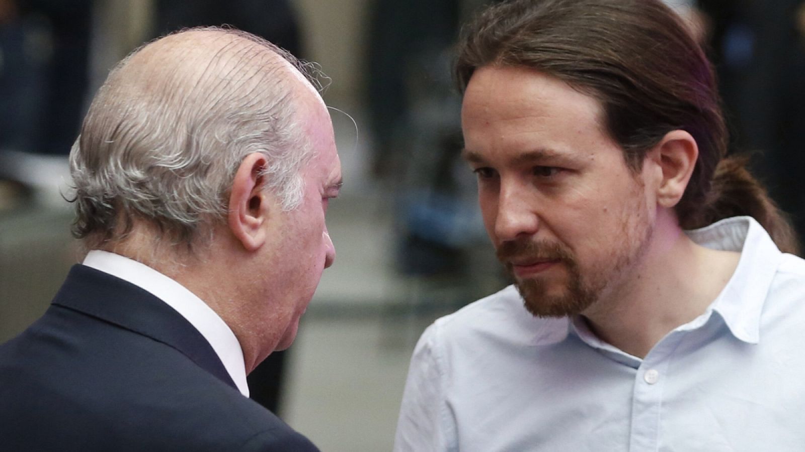 El líder de Podemos, Pablo Iglesias, conversa con el exministro de Interior Jorge Fernández Díaz