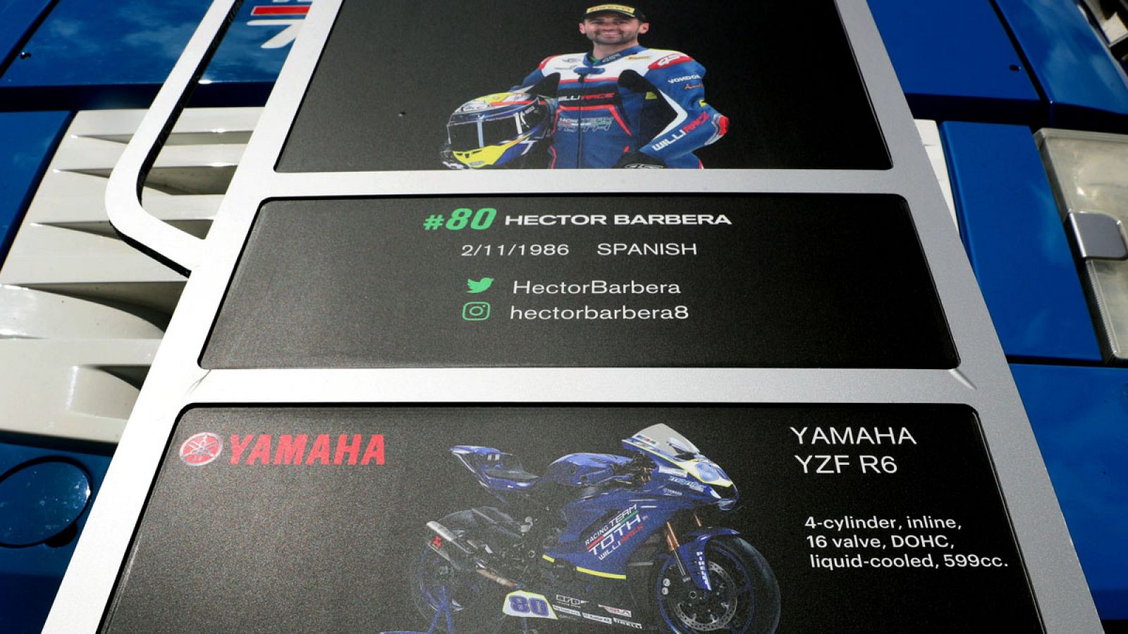 Cartel en el paddock con la imagen de Héctor Barberá y la moto