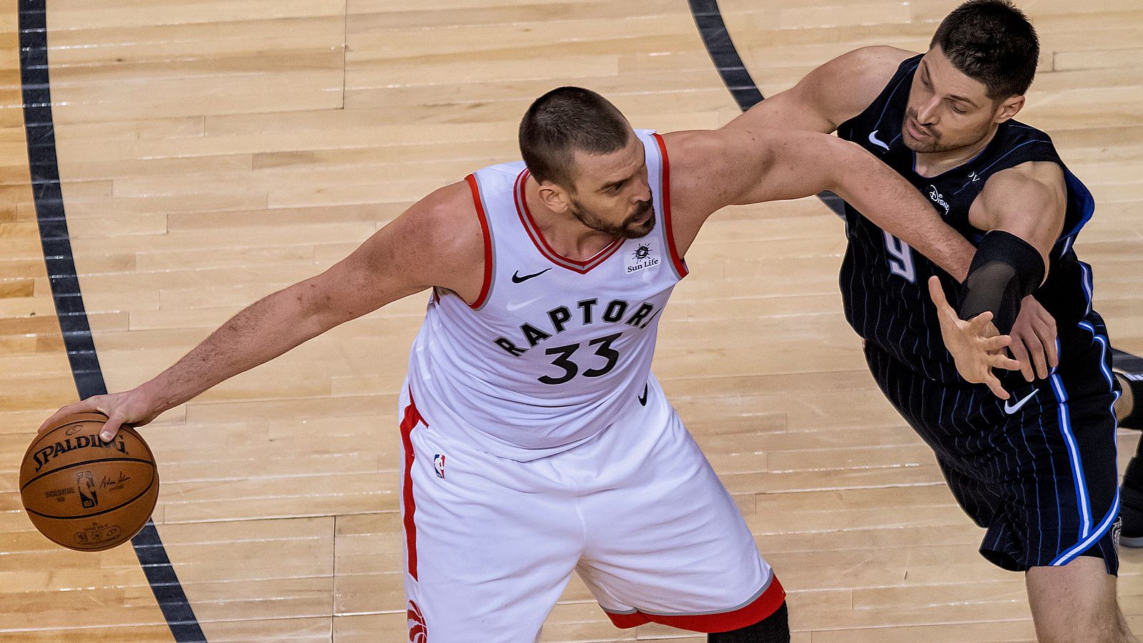 El jugador Marc Gasol (i) de Toronto Raptors en acción ante Nikola Vucevic (d) de Orlando Magic