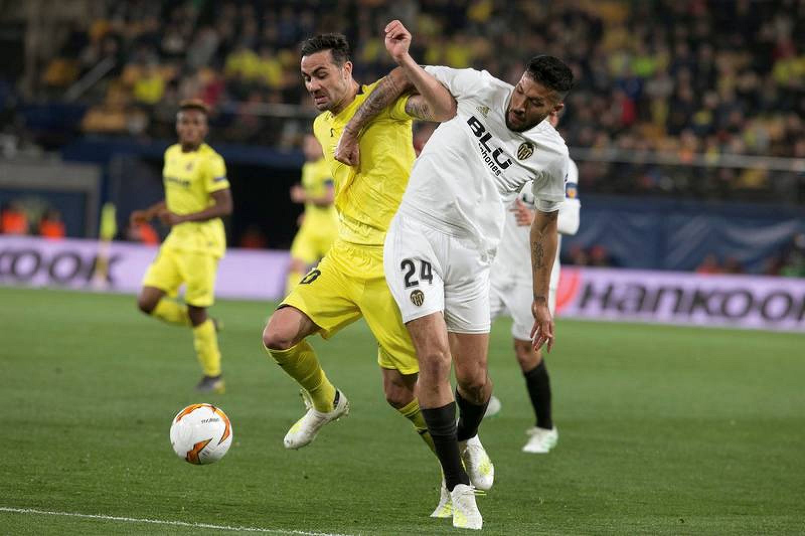 El centrocampista del Villarreal, Vicente Iborra (i), disputa el balón ante el defensa argentino del Valencia, Ezequiel Garay, durante el encuentro de ida.