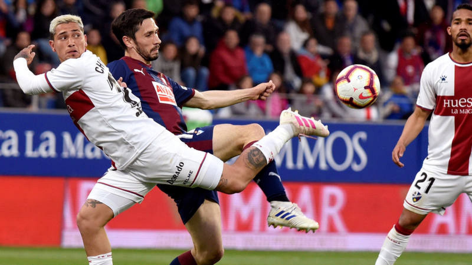 Ezequiel Ávila, del Huesca, pugna un balón con Paulo Oliveira, del Eibar.