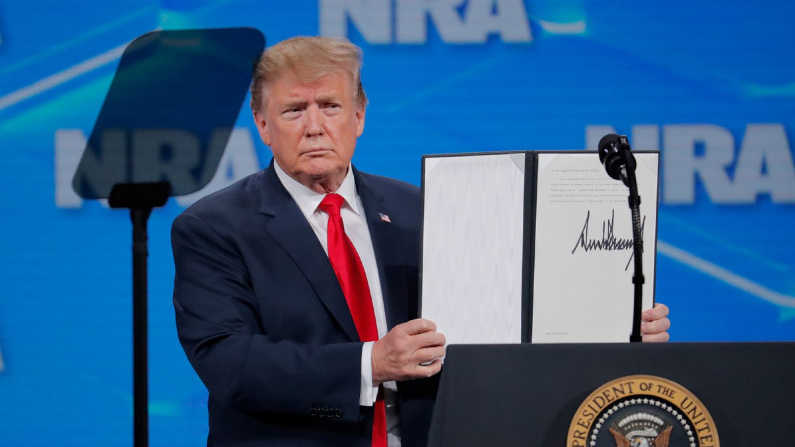 Trump muestra la Orden Ejecutiva con su firma mientras anuncia que revocará el estatus de Estados Unidos como firmante del Tratado sobre Comercio de Armas