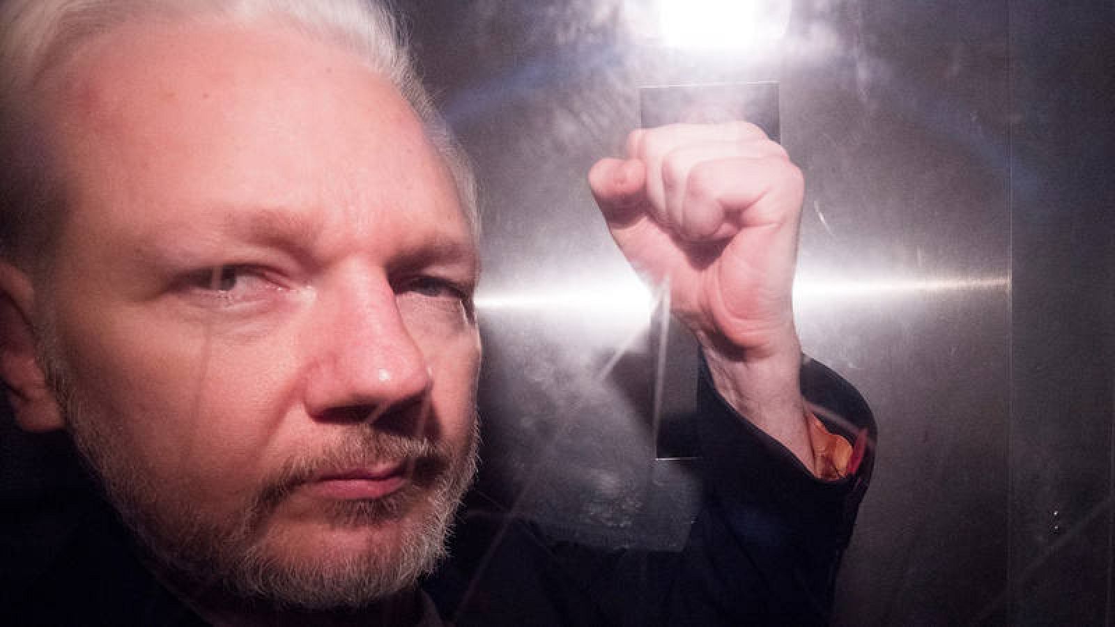El fundador de Wikileaks, Julian Assange, saluda a los fotógrafos mientras abandona en un vehículo policial, este miércoles, el tribunal de Southwark de Londres (Reino Unido). Efe/Neil Hall