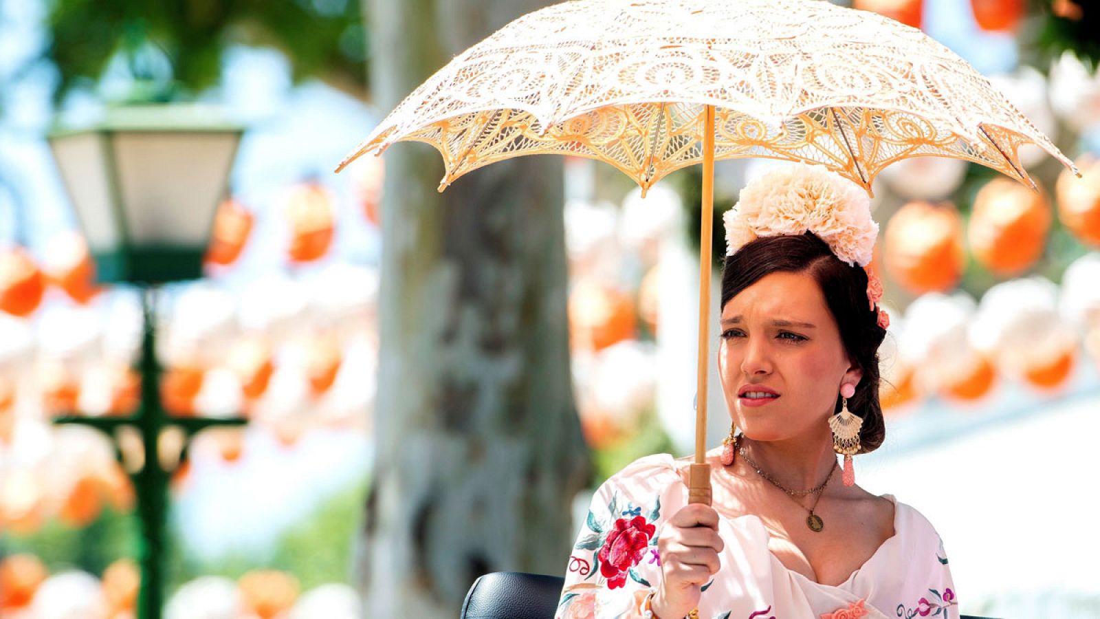 Una mujer pasea en carruaje por el Real de la Feria de Abril de Sevilla bajo un calor veraniego