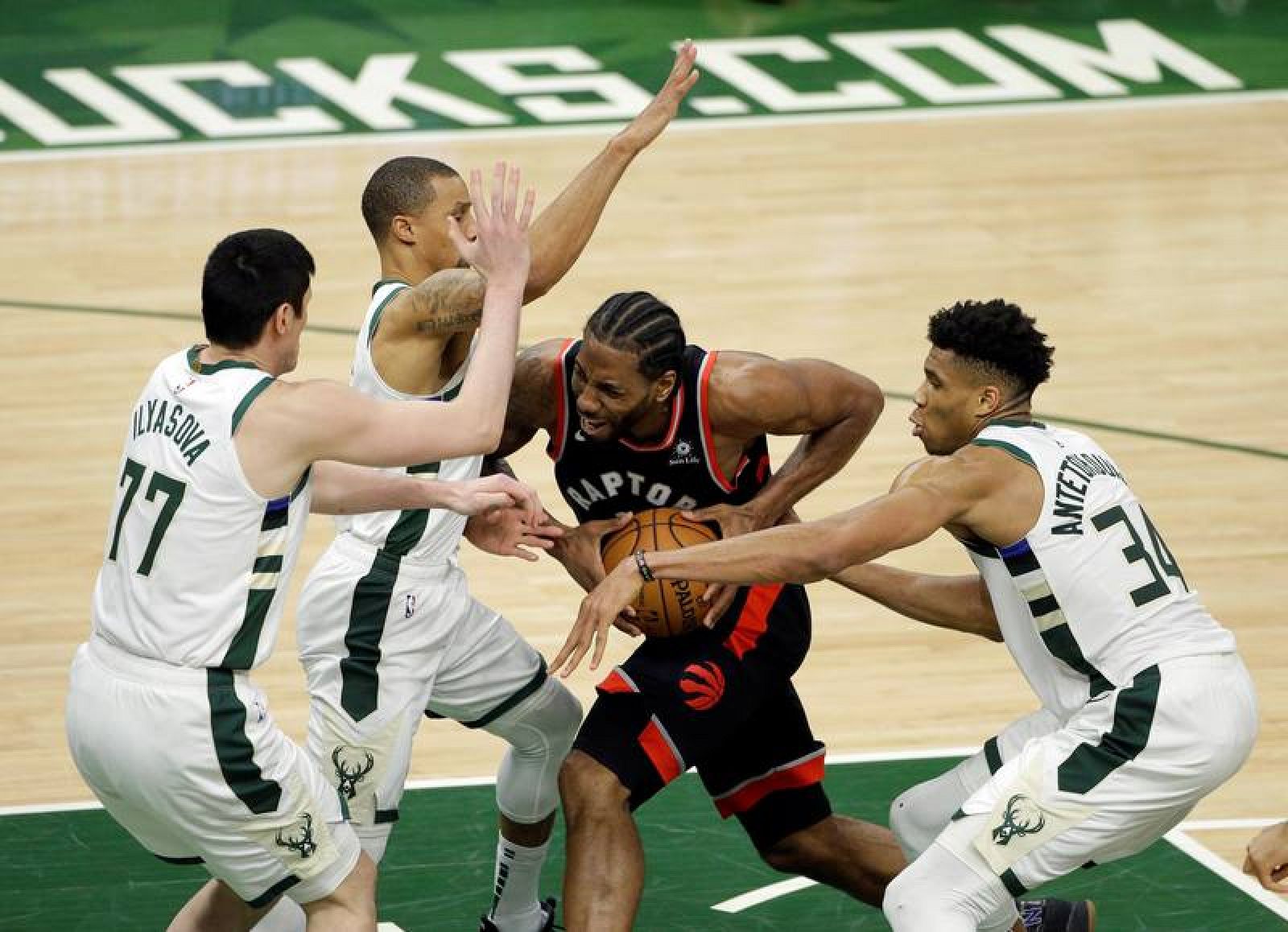 Jugadores de Milwaukee Bucks tratan de parar a Kawhi Leonard 2(d) de Toronto Raptors este miércoles, durante el primer juego de la final de la Conferencia Este de la NBA, entre Toronto Raptors y Milwaukee Bucks, en Fiserv Forum en Milwaukee 