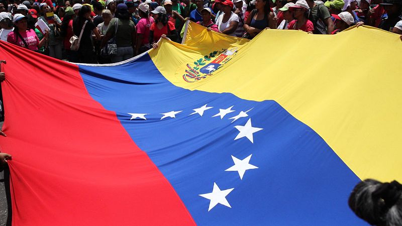 Simpatizantes del chavismo ondeando una bandera de Venezuela durante una marcha en Caracas (Venezuela).