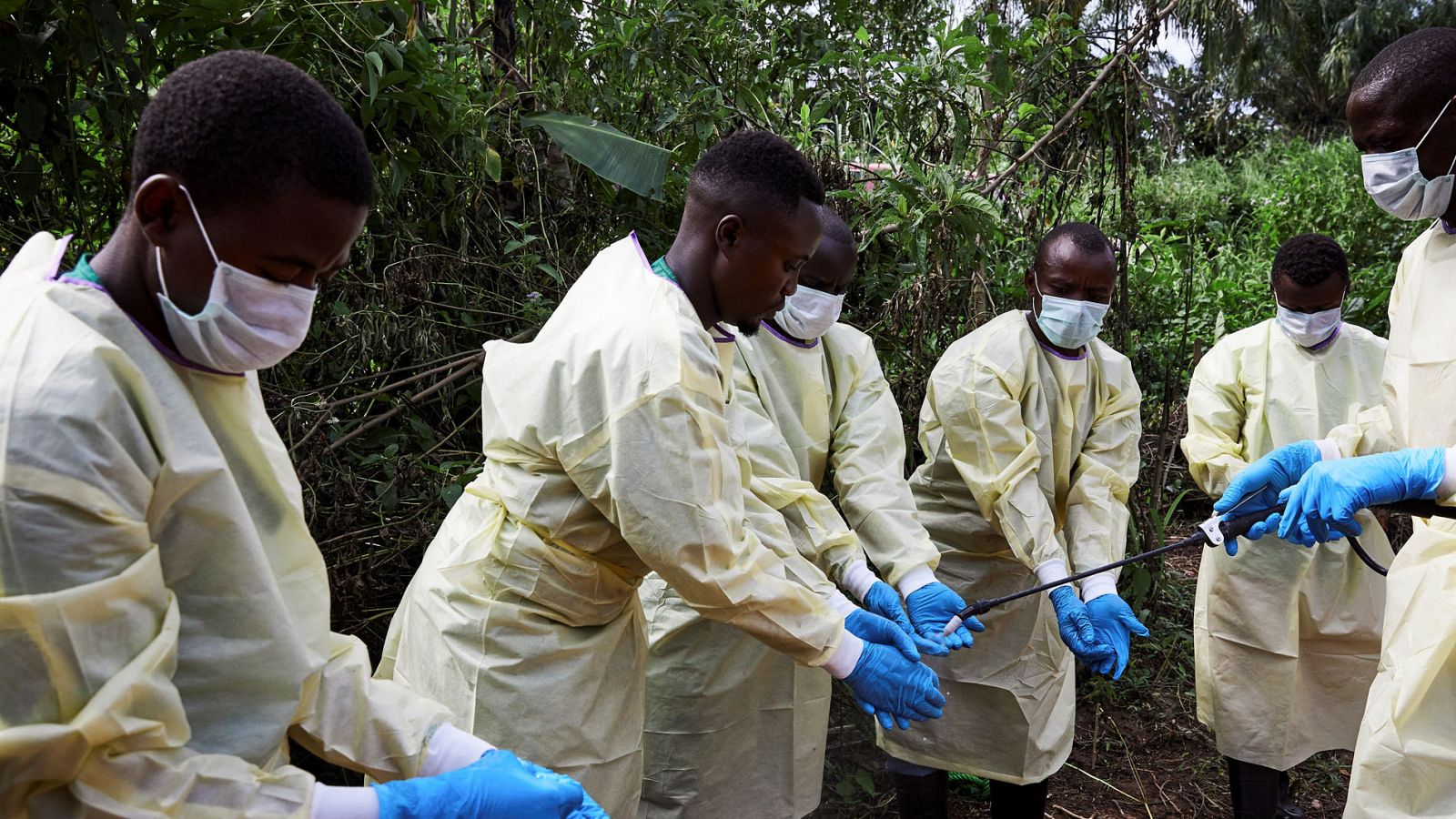 Trabajadores sanitarios se desinfectan tras enterrar a un bebé de once meses en un cementerio de víctimas del ébola en Beni, en la República Democrática del Congo