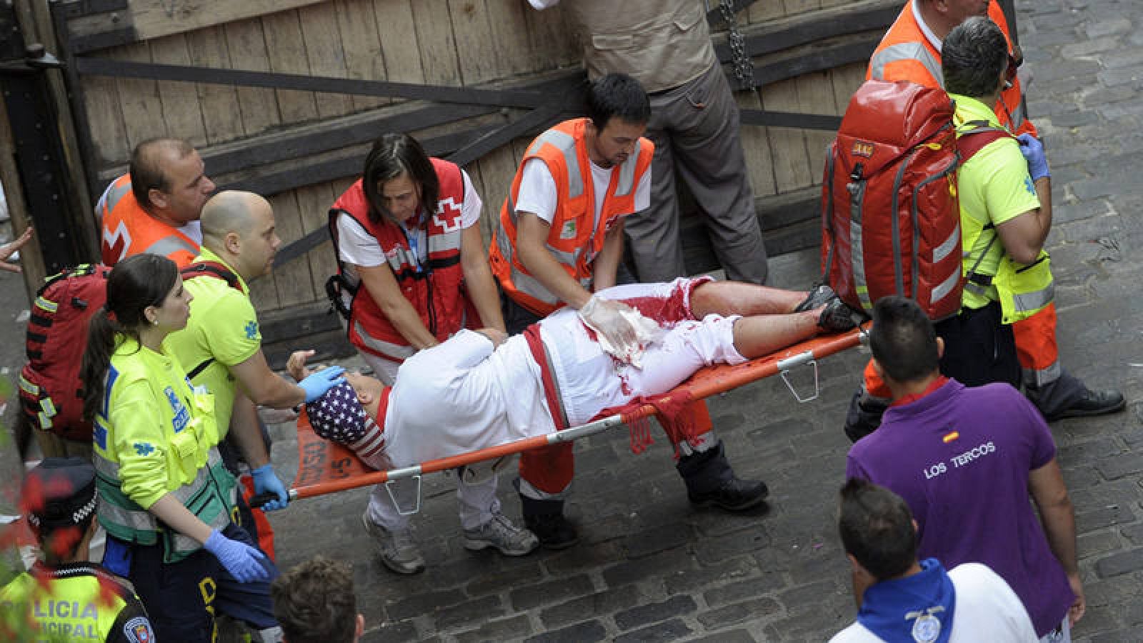 Un mozo es trasladado por los servicios sanitarios tras ser corneado en los encierros de Sanfermines