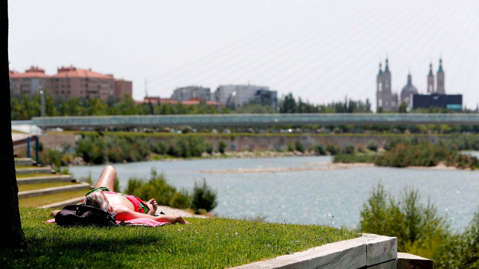 En la imagen, un hombre toma el sol en la ribera del Ebro.