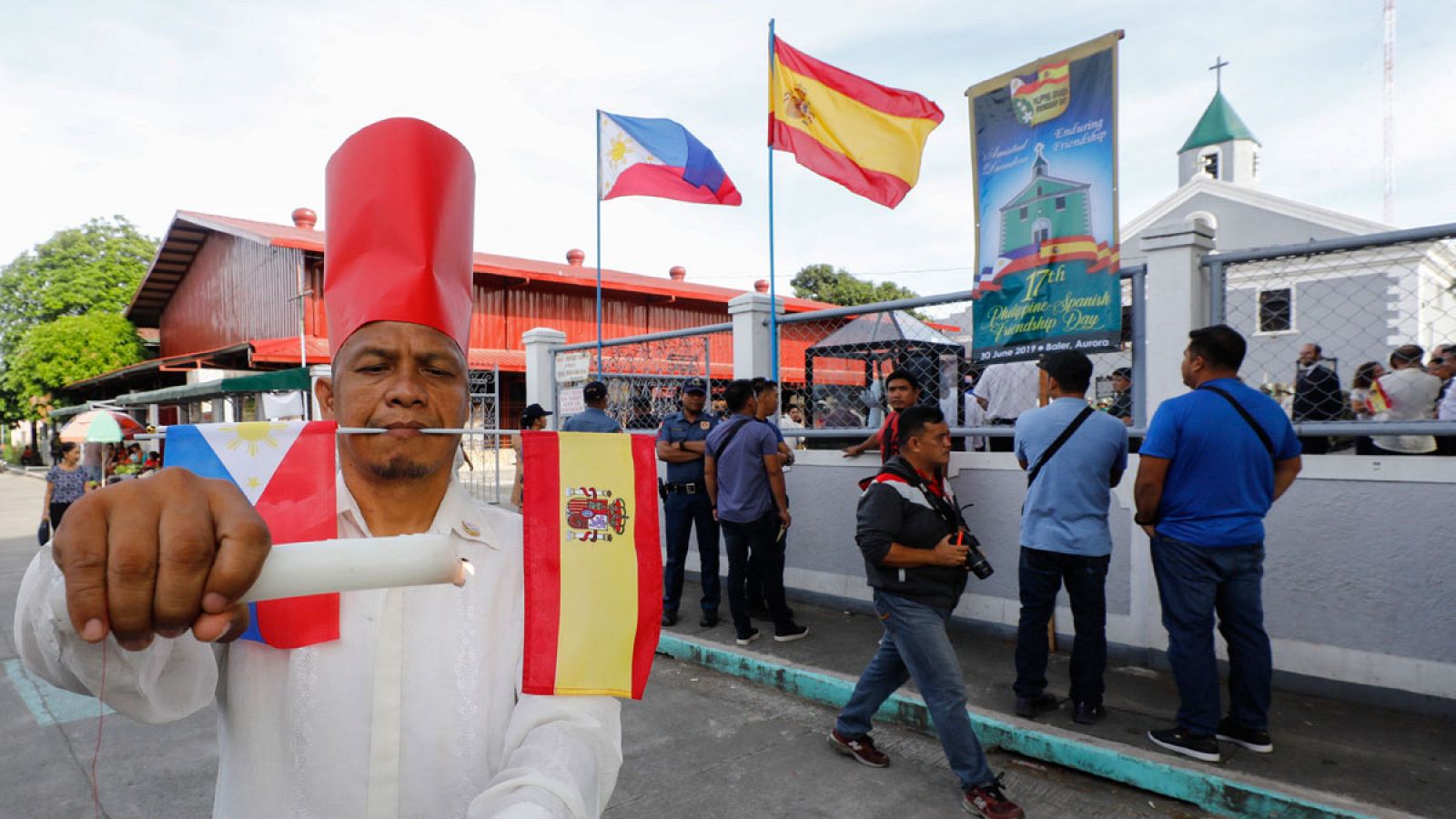 Un artista callejero hace una performance con las banderas de Filipinas y España en la boca.