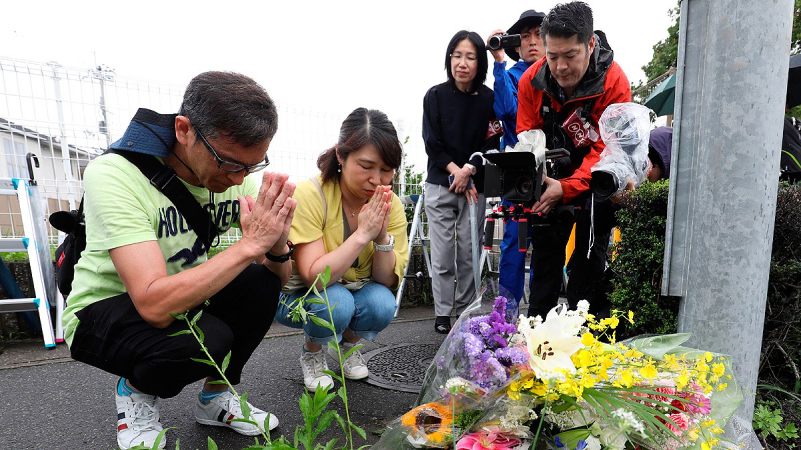 Un grupo de personas deposita flores en el exterior de los estudios Kyoto Animation, donde un incendio causó la muerte de decenas de personas.