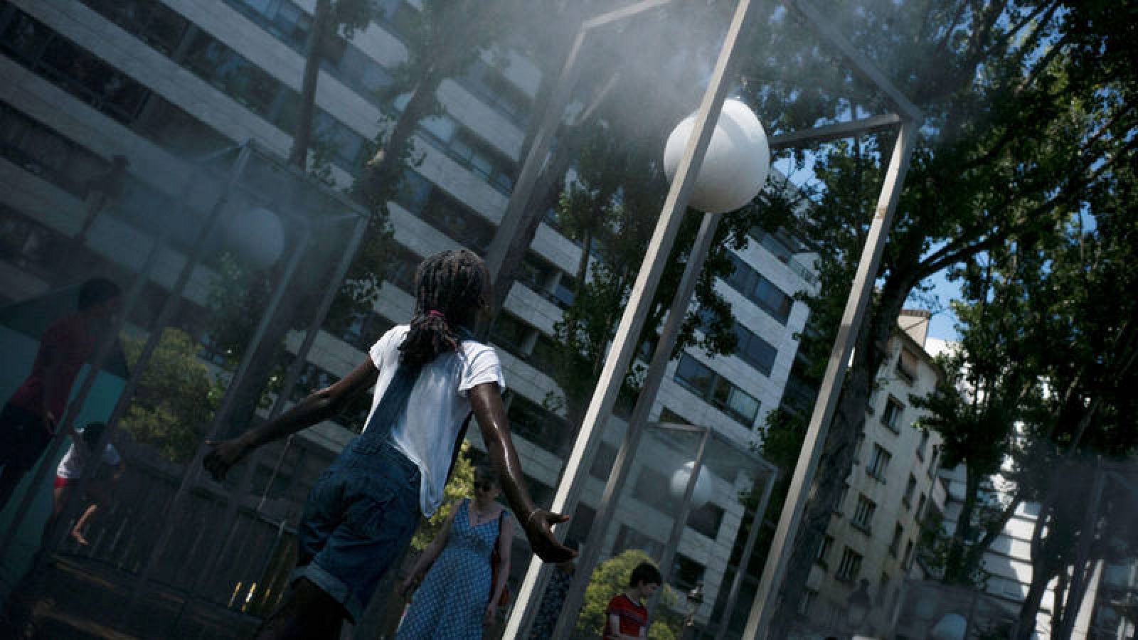 Niña refrescándose en la calle en París