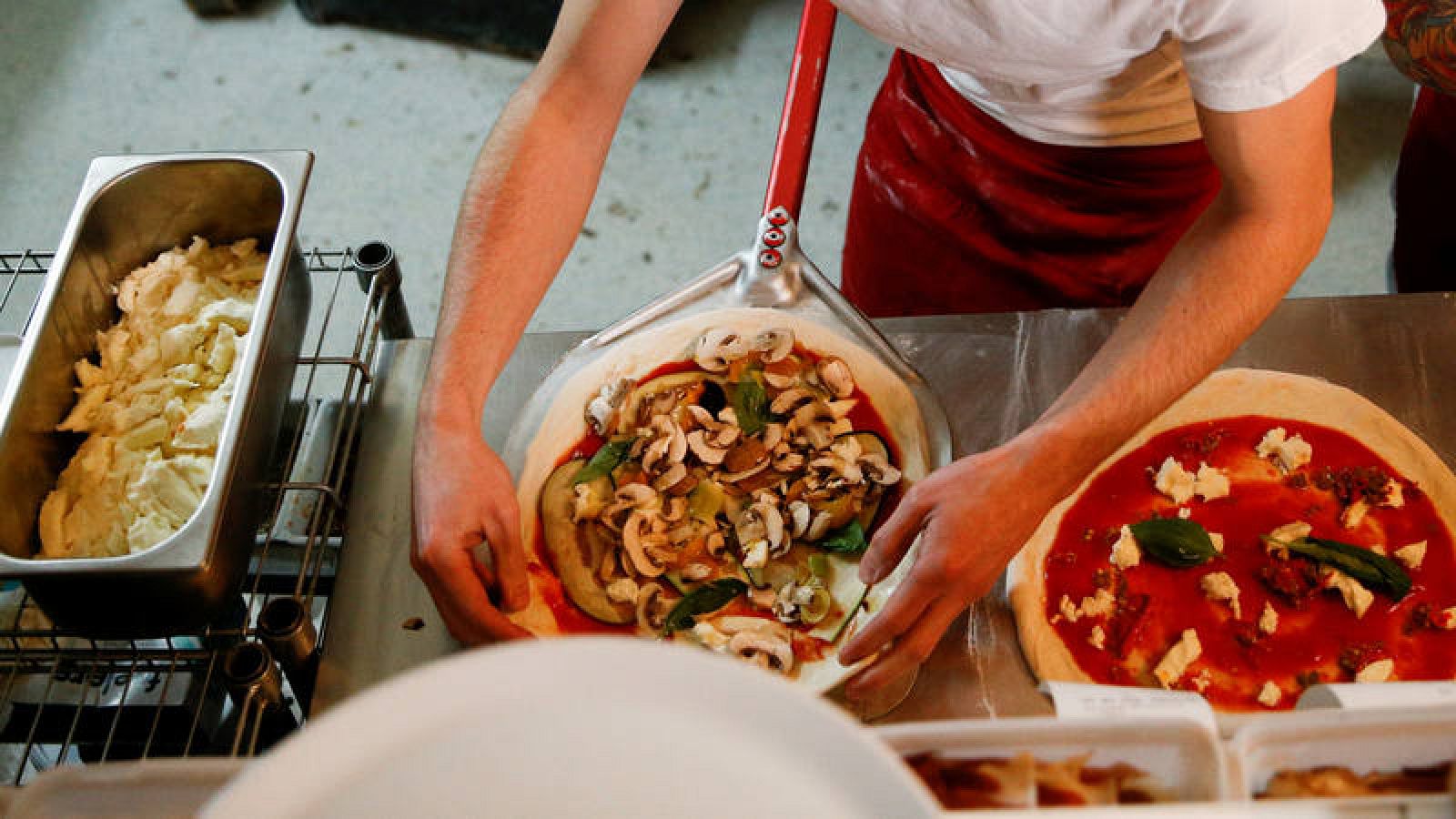 Un cocinero prepara una pizza en una pizzería de Londres.
