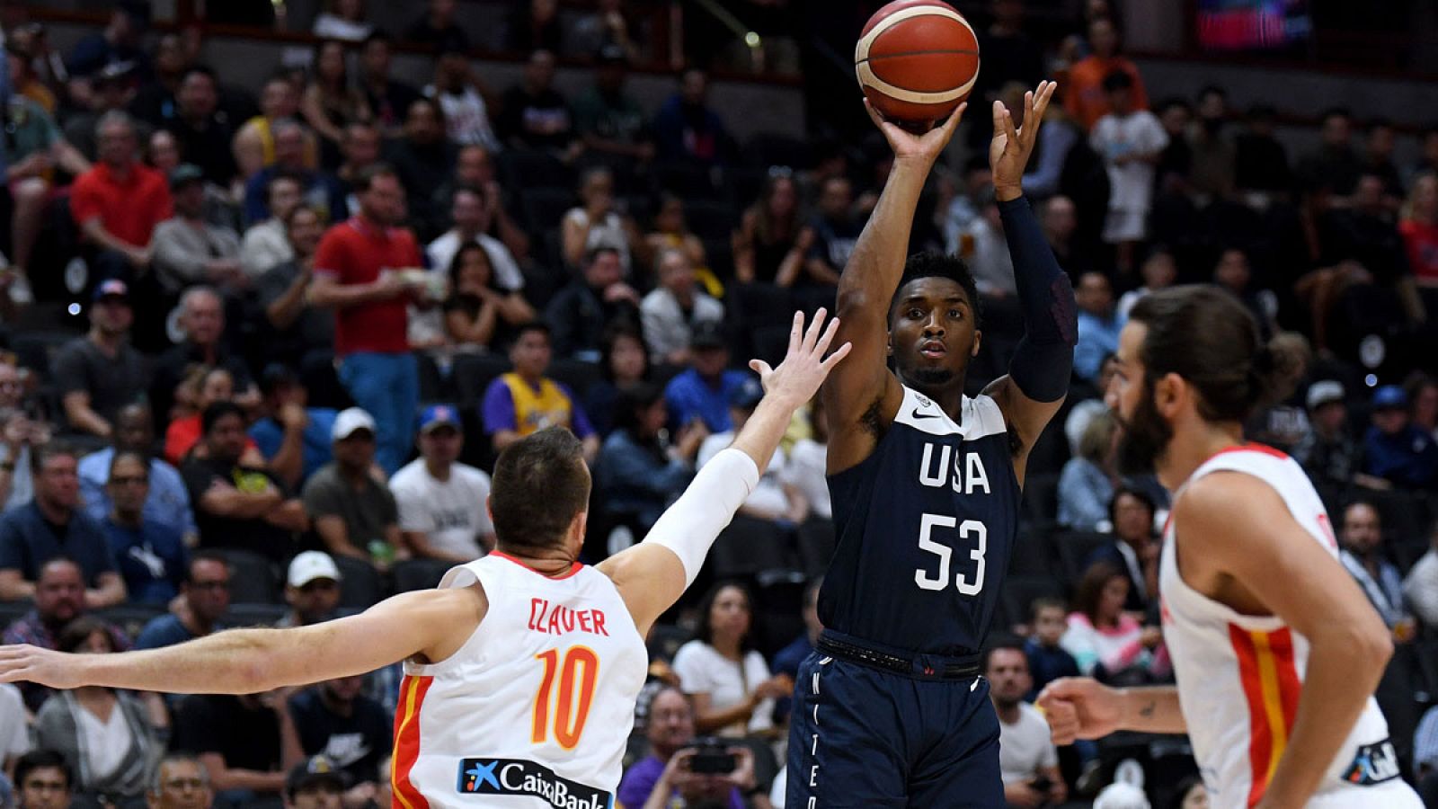 El estadounidense Donovan Mitchell (c) lanzando a canasta entre los españoles 
Victor Claver (i) y Ricky Rubio (d).