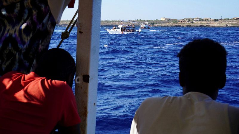 Algunos de los 107 migrantes en el interior del barco de la ONG española Open Arms, que sigue bloqueado desde hace 18 días junto a la isla italiana de Lampedusa. EFE/Francisco Gentico