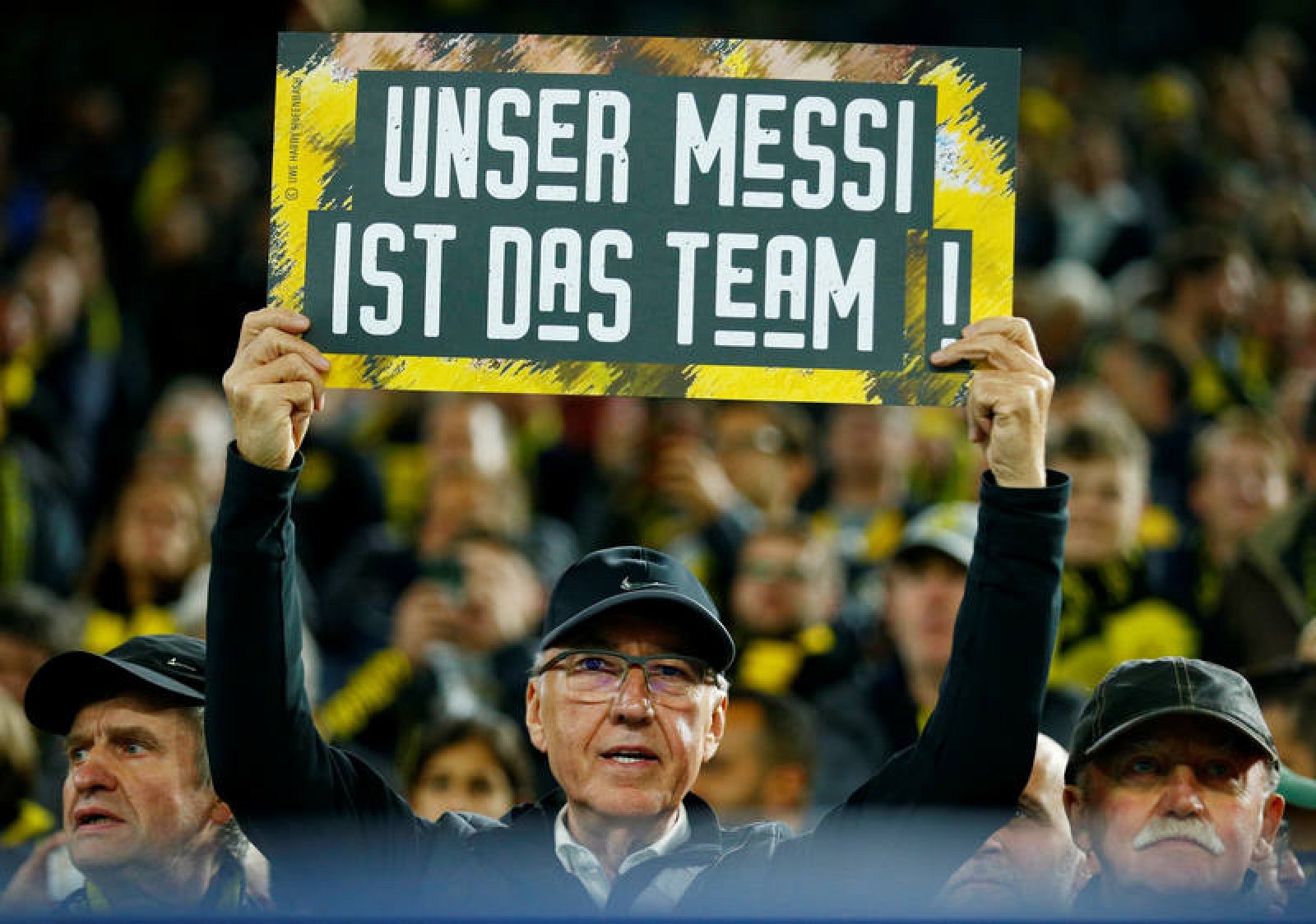 Un aficionado del Dortmund muestra una pancarta que dice en alemán: "Nuestro Messi es el equipo"