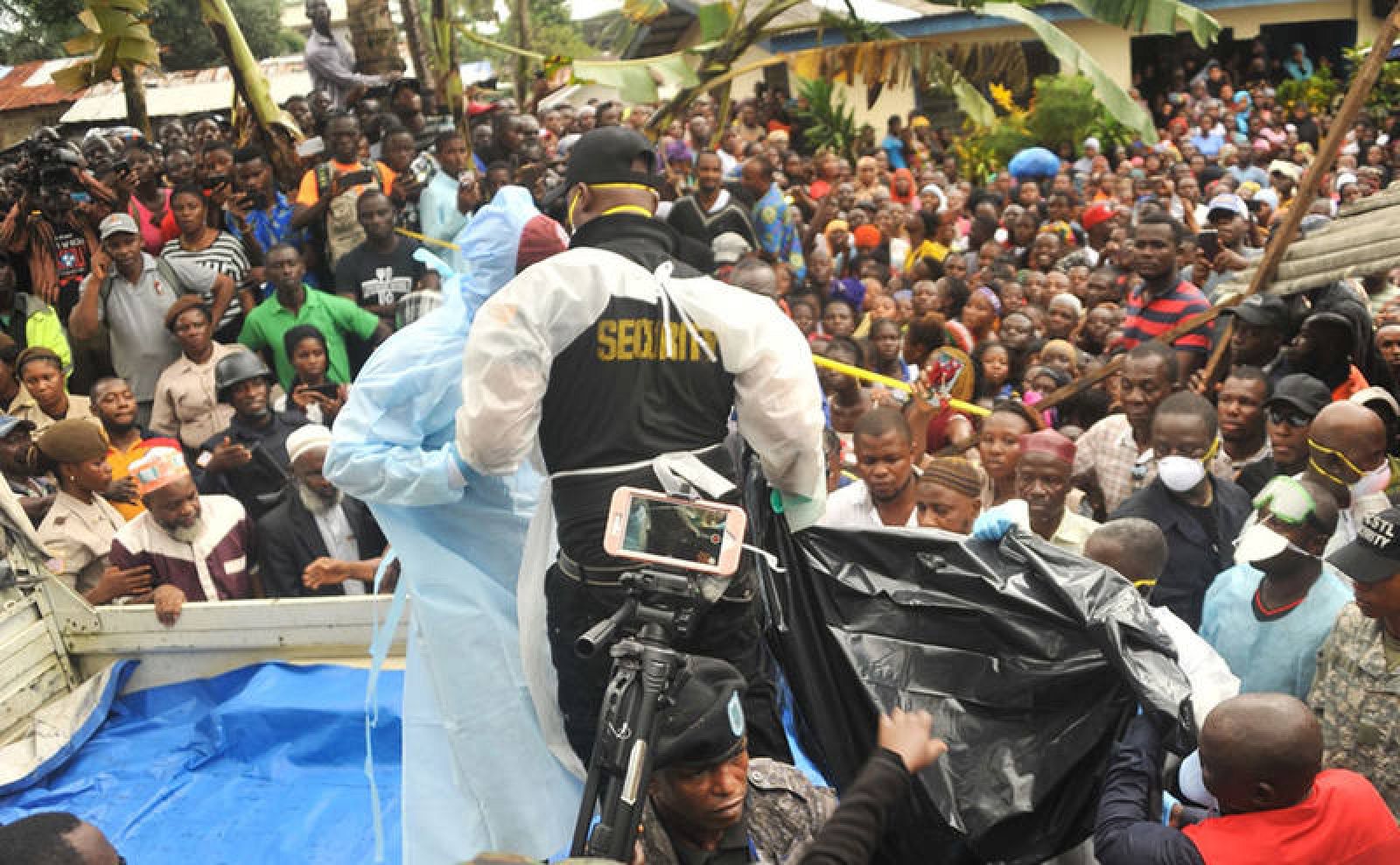  Miembros de los equipos de rescate sostienen el cuerpo de una de las víctimas en el incendio.