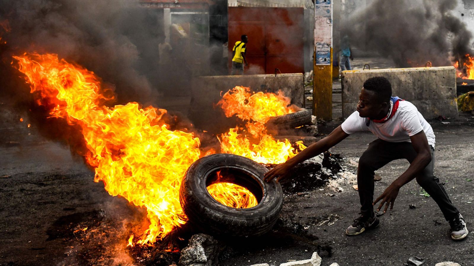 Un hombre prendiendo fuego a un neumático durante la protesta contra el Gobierno en Puerto Príncipe, Haití.