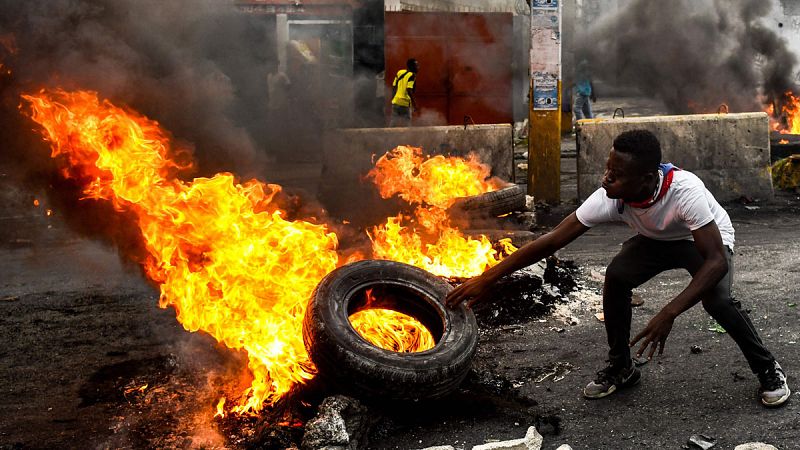 Un hombre prendiendo fuego a un neumático durante la protesta contra el Gobierno en Puerto Príncipe, Haití.