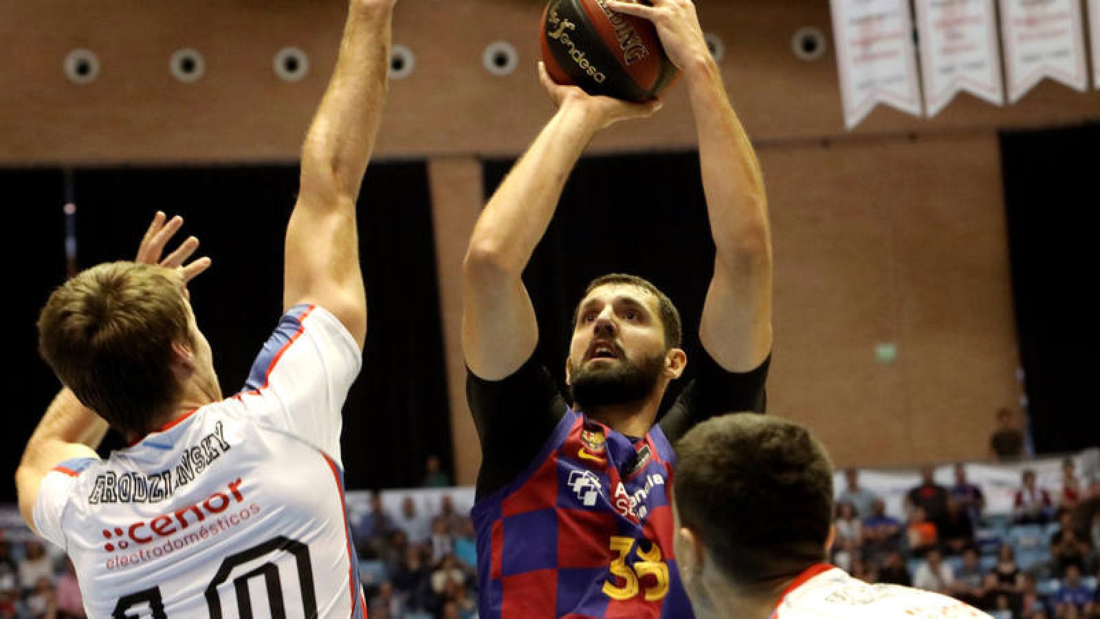 El ala-pívot del Barcelona, Nikola Mirotic (c) lanza ante la defensa