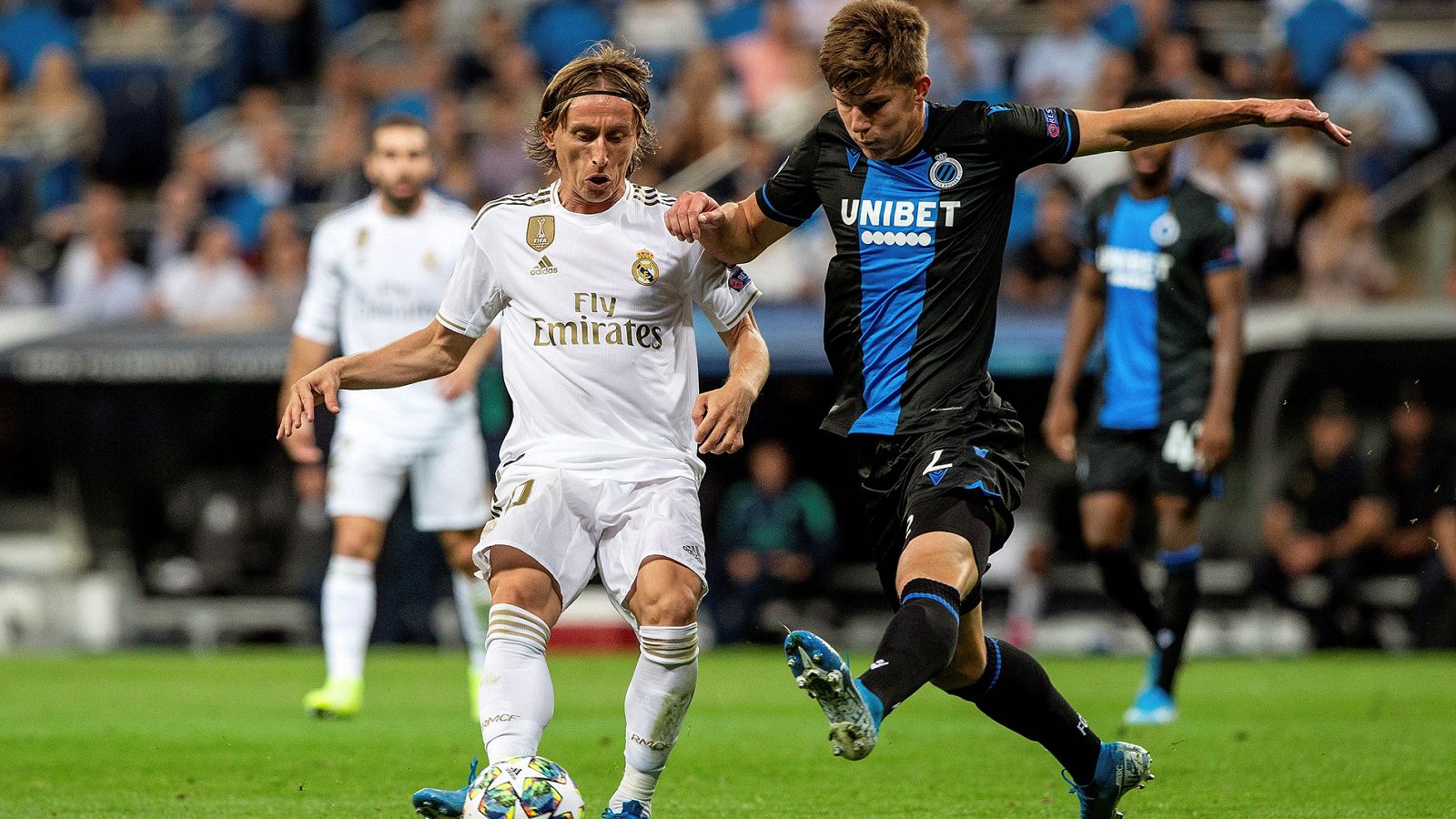 El centrocampista croata del Real Madrid, Luka Modric pelea un balón con el defensa ucraniano del Club Brujas, Eduard Sobol.