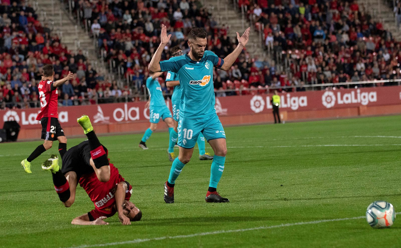 El jugador del Mallorca Dani Rodríguez (i) cae ante el del Osasuna Roberto Torres (d), este jueves durante el partido de la undécima jornada de Liga en el estadio Son Moix