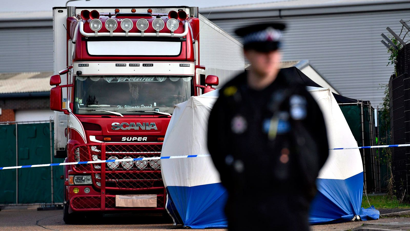 Un agente custodia el camión donde fueron hallados los cadáveres de los migrantes en el polígono de Grays, en Essex