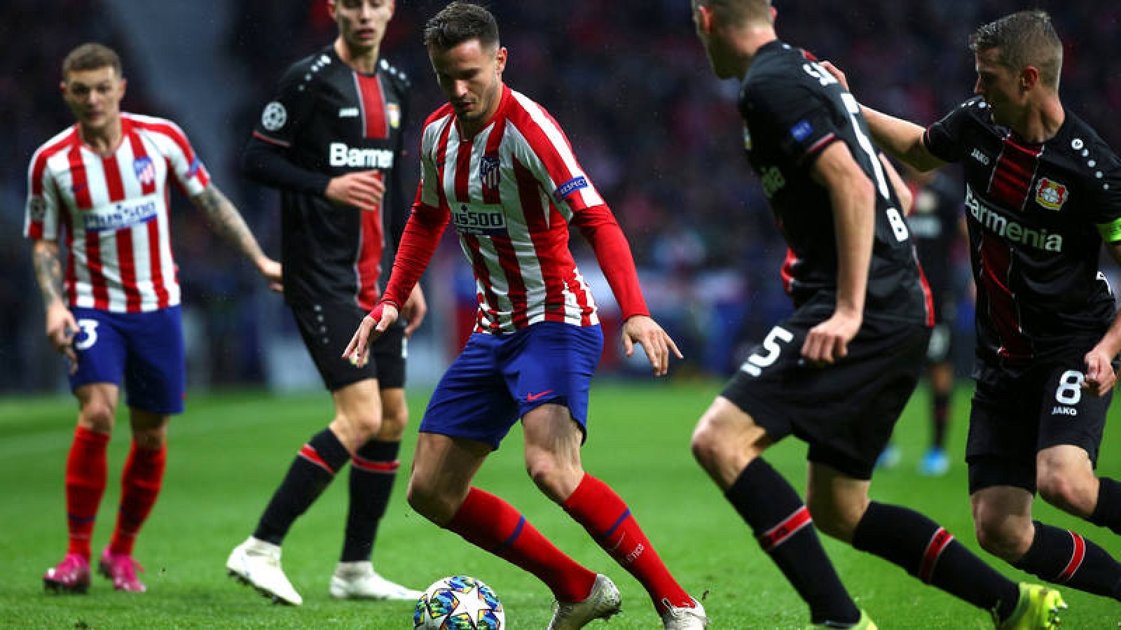 Saúl Ñíguez pugna un balón con Lars (2d) y Sven Bender (d), defensas alemanes del Bayer Leverkusen, en el partido anterior.