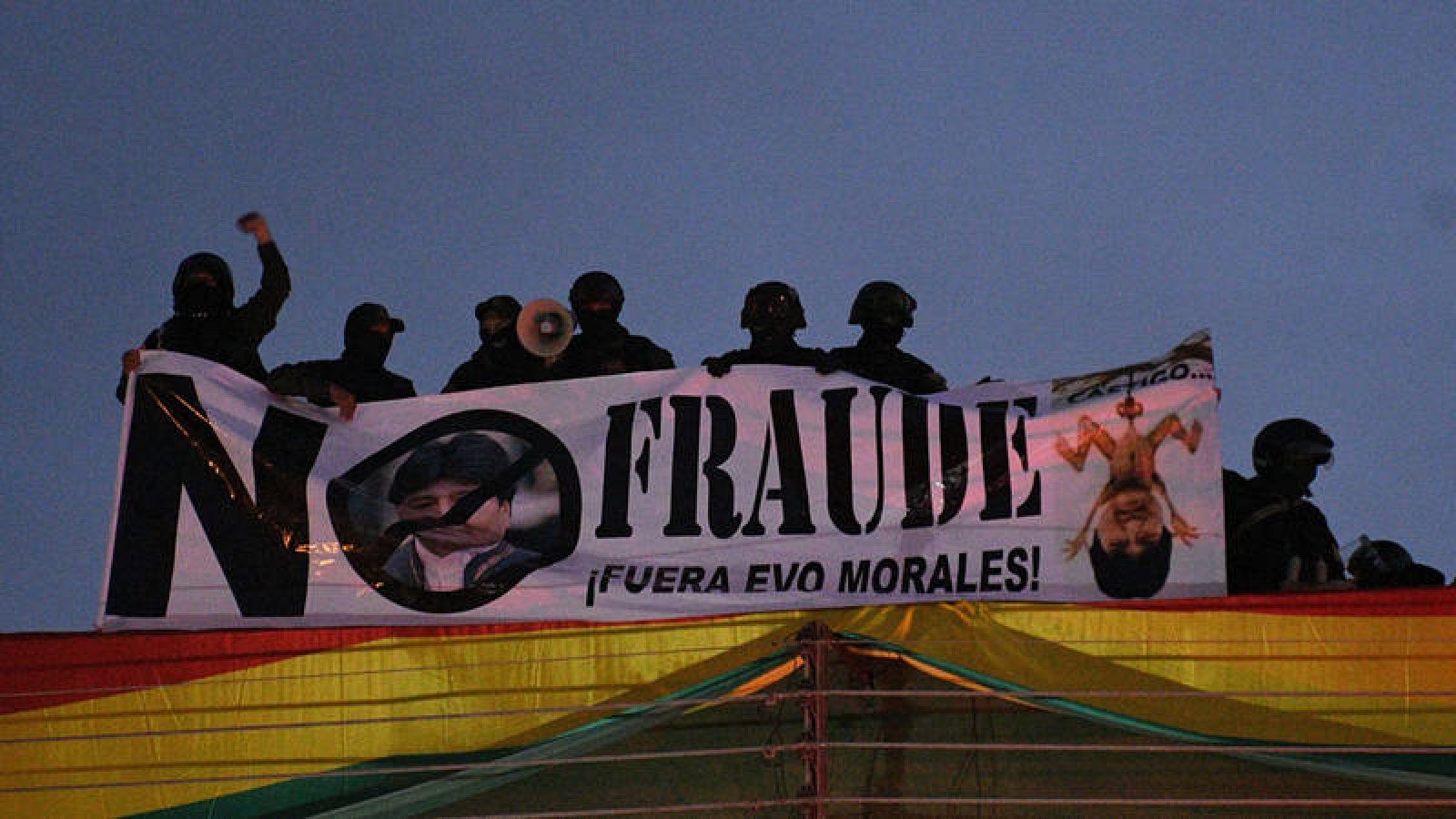 Policías bolivianos desplegando una pancarta contra Evo Morales en el techo de una unidad policial en Cochabamba.