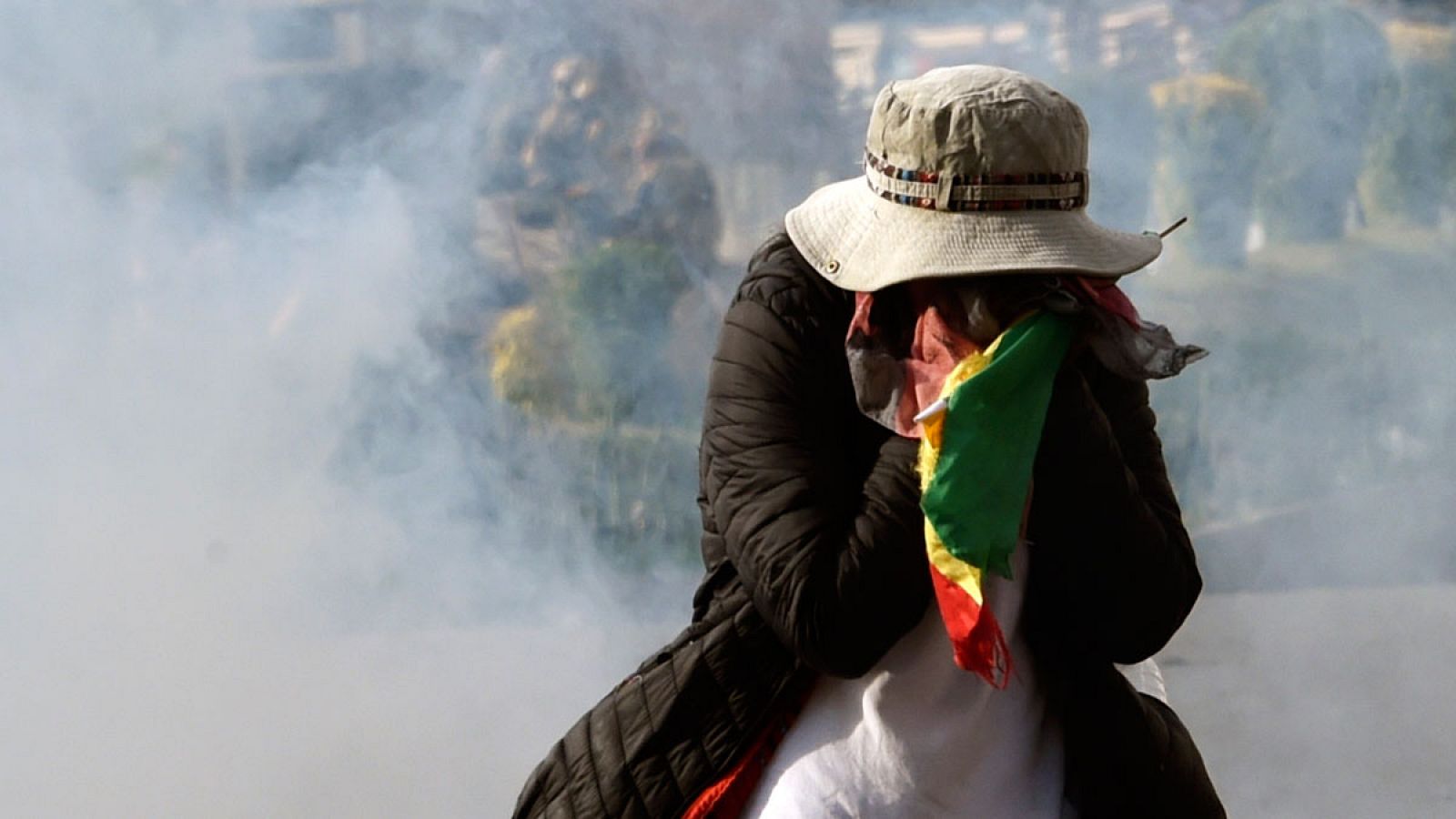 Un manifestante protegiéndose  del gas lacrimógeno durante una protesta contra el gobierno interino en La Paz, Bolivia.