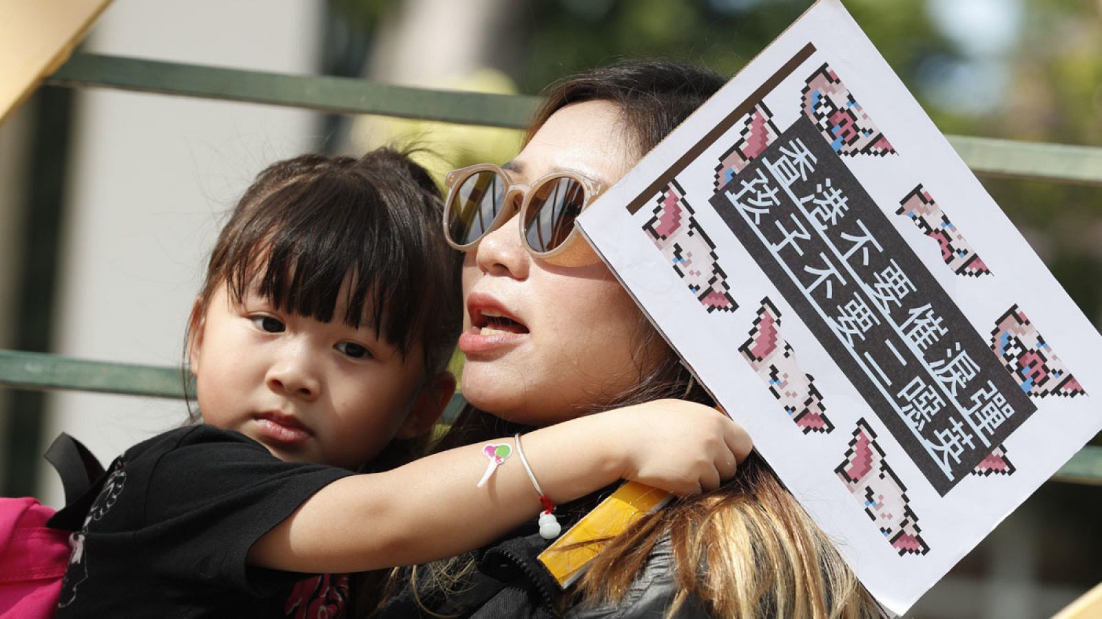 Manifestantes con una pancarta en la que se puede leer "Dejad de matar a nuestros hijos" durante una marcha en Hong Kong, 